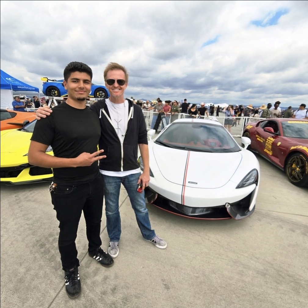 Morrissey Rodriguez with a client beside a McLaren at a supercar event
